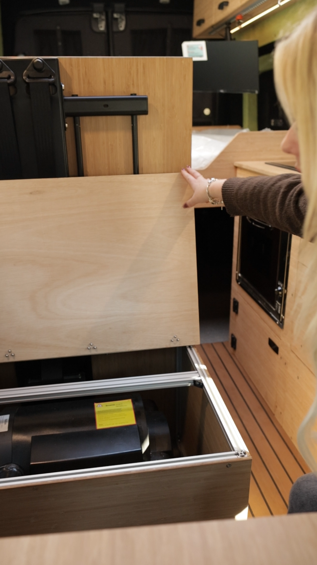 Hidden under-bed storage compartment in campervan conversion