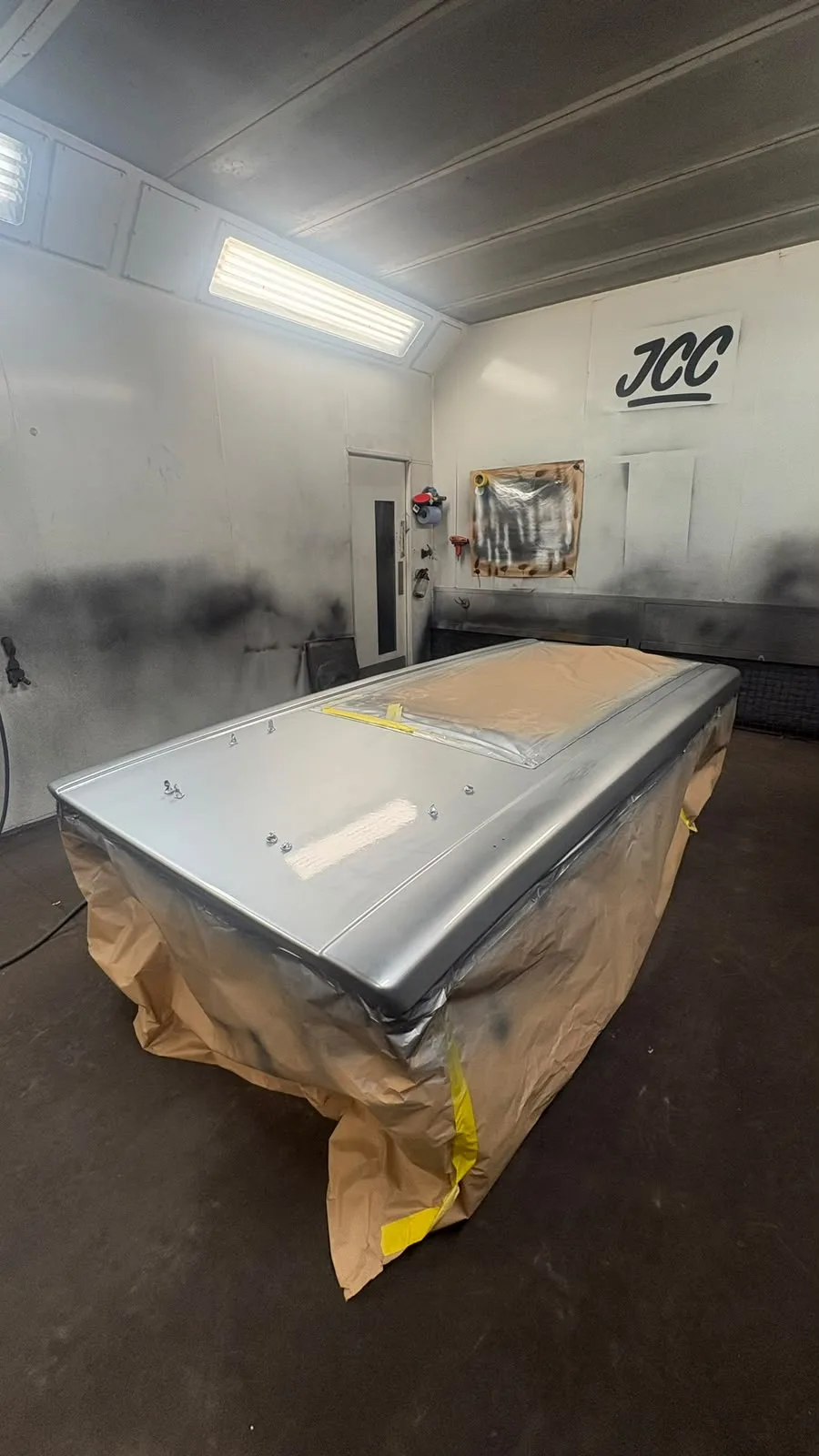 Pop-top roof shell on a work stand in the spray booth