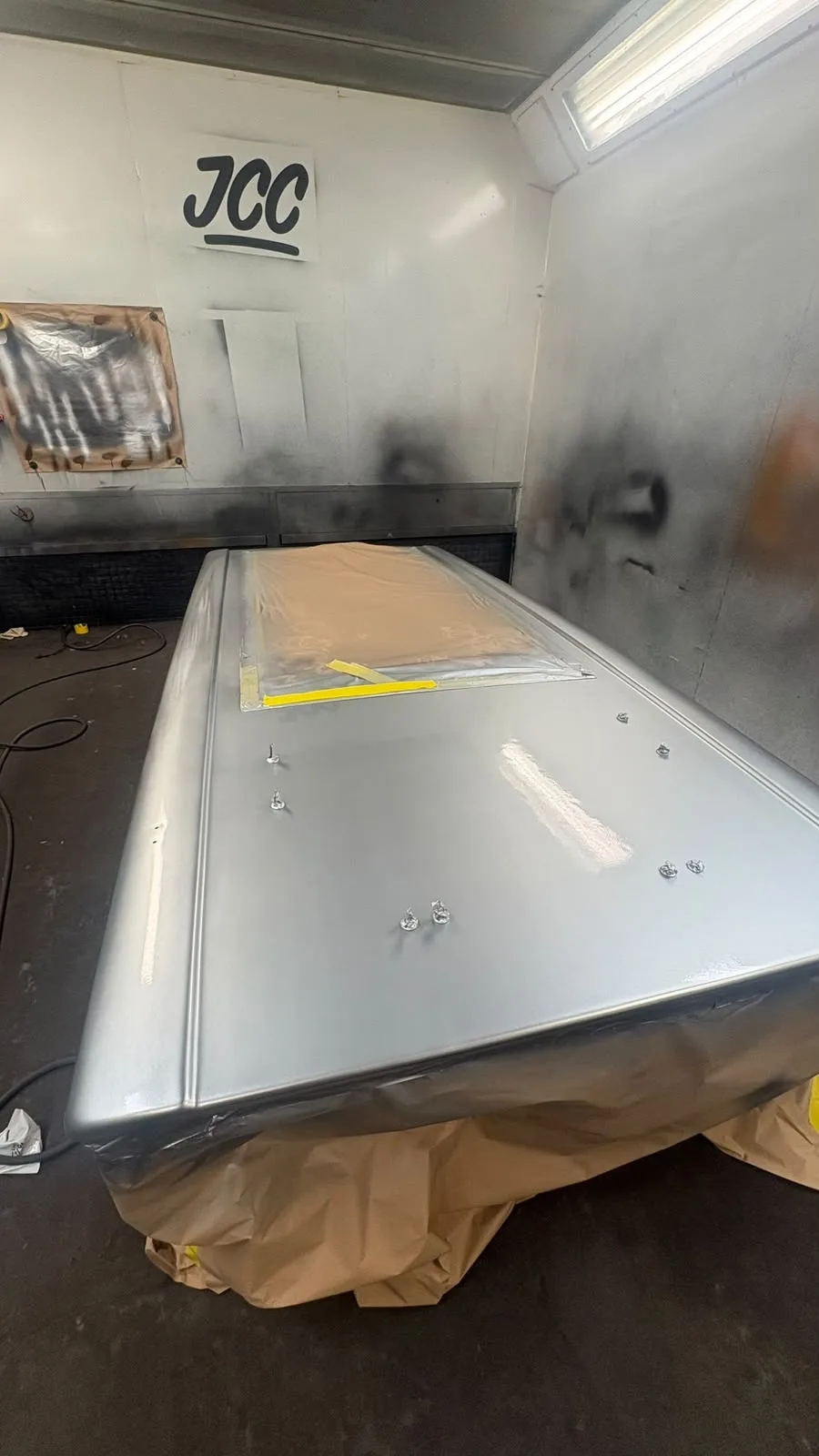 Fibreglass pop-top roof shell masked and prepared in the JCC spray booth